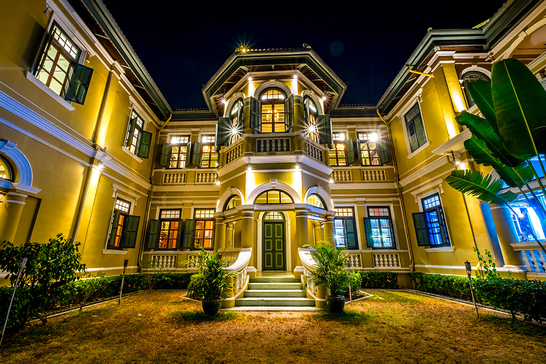 A mansion at night with a green door